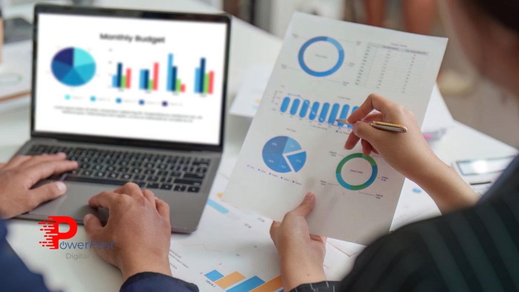 Business professionals analyzing digital marketing budget reports with charts and graphs on laptop and paper